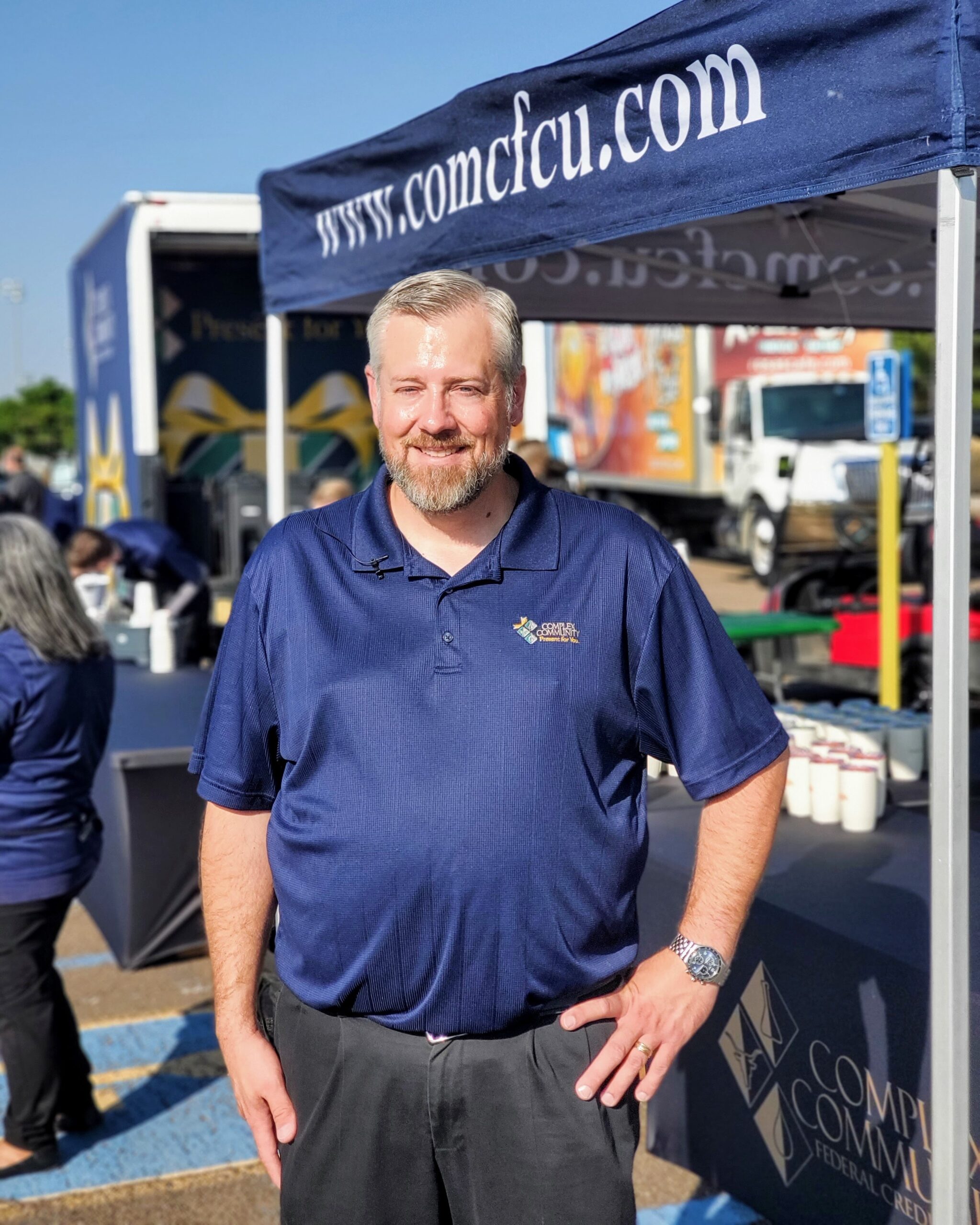 Smiling volunteer painting a community mural, representing Complex Community Federal Credit Union’s commitment to local service and member support.